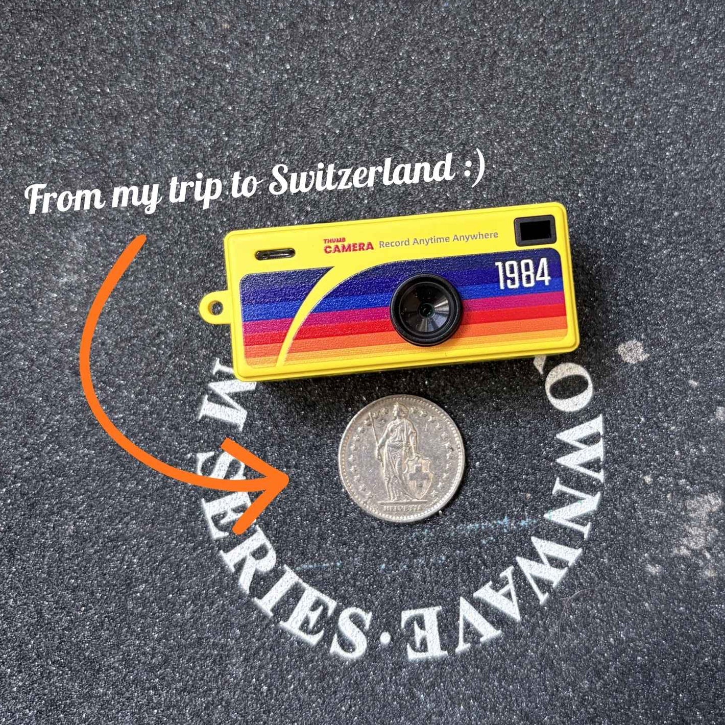 Colorful camera-shaped object with text on a textured surface